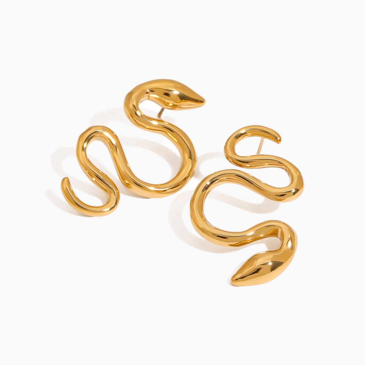 Gold snake-shaped earrings on a white background