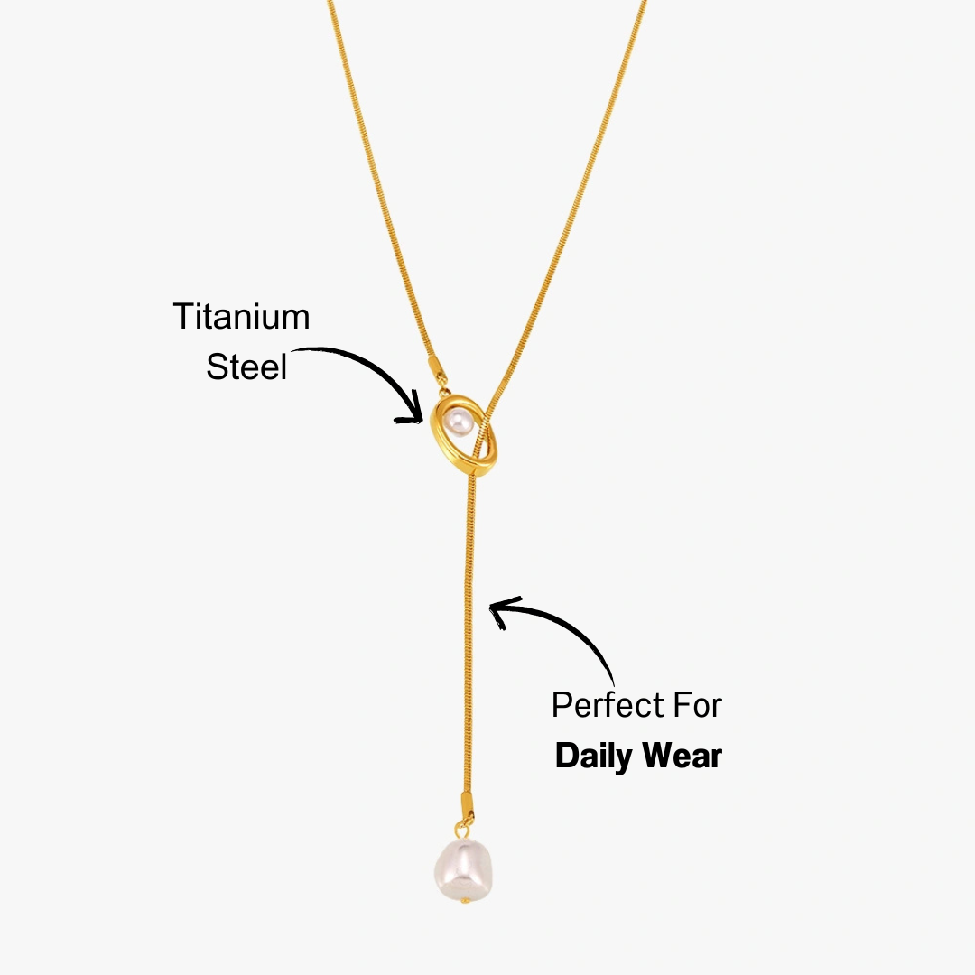 14k gold-plated titanium necklace with a white pearl drop, displayed on a beige surface with soft lighting
