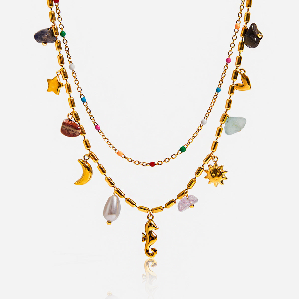 Gold necklace with various charms on a white background