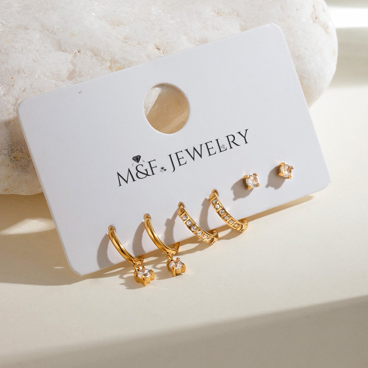 Full jewelry card set from M&F Jewelry featuring zircon studs, pavé hoops, and charm drops.