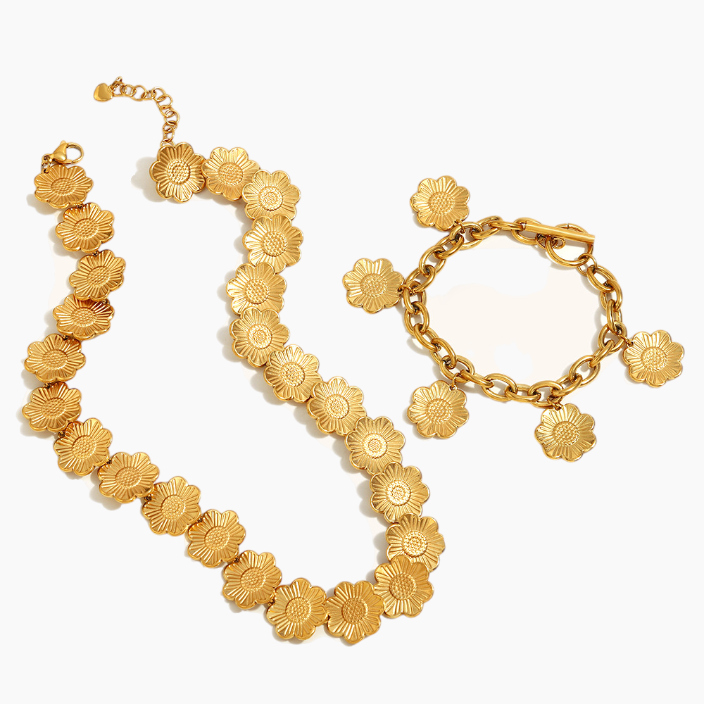 Gold floral bracelet and necklace set on a white background