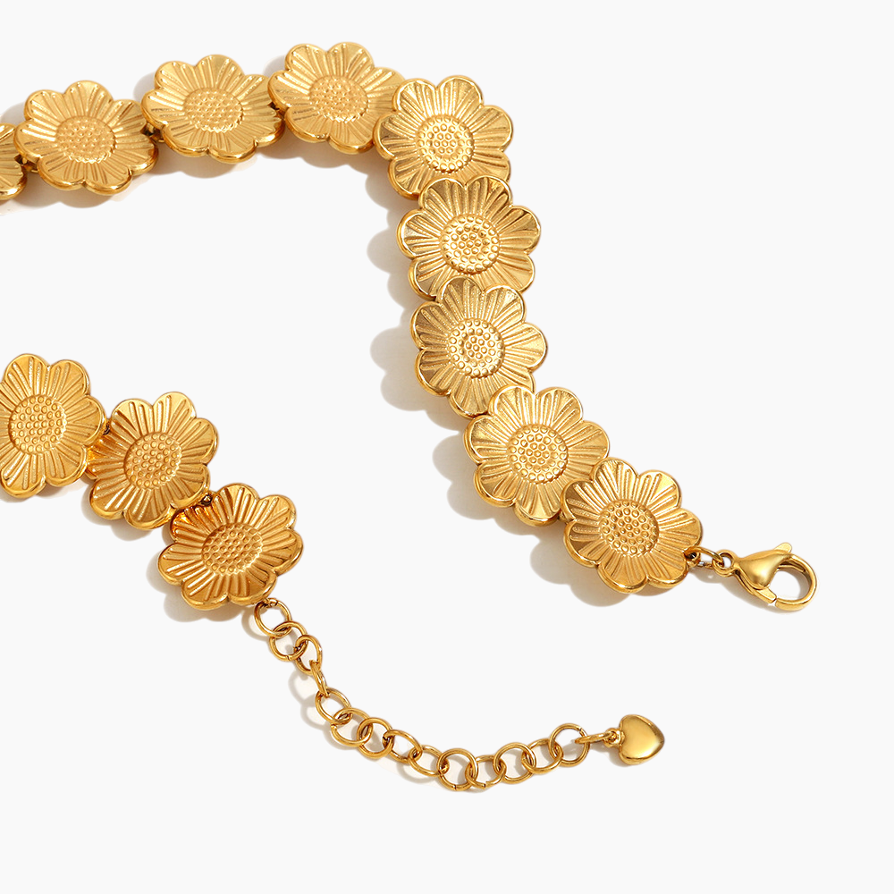 Gold bracelet with floral designs on a white background