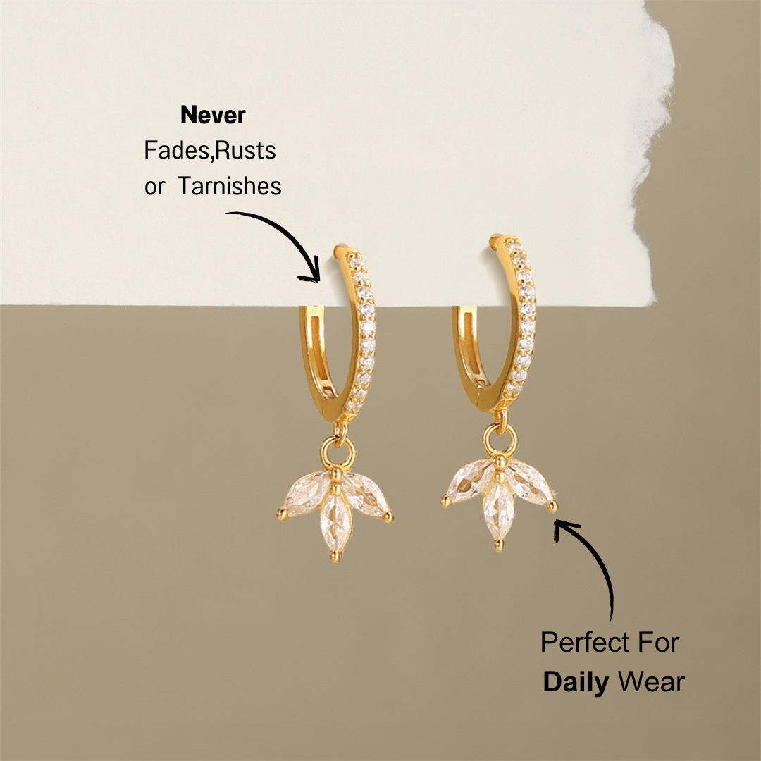 925 sterling silver drop earrings with a leaf design and cubic zirconia stones, elegantly displayed with a soft background.