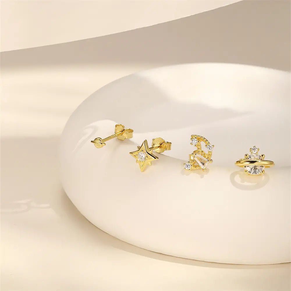 925 sterling silver celestial earring set with zirconia star and planet designs displayed against a soft background.