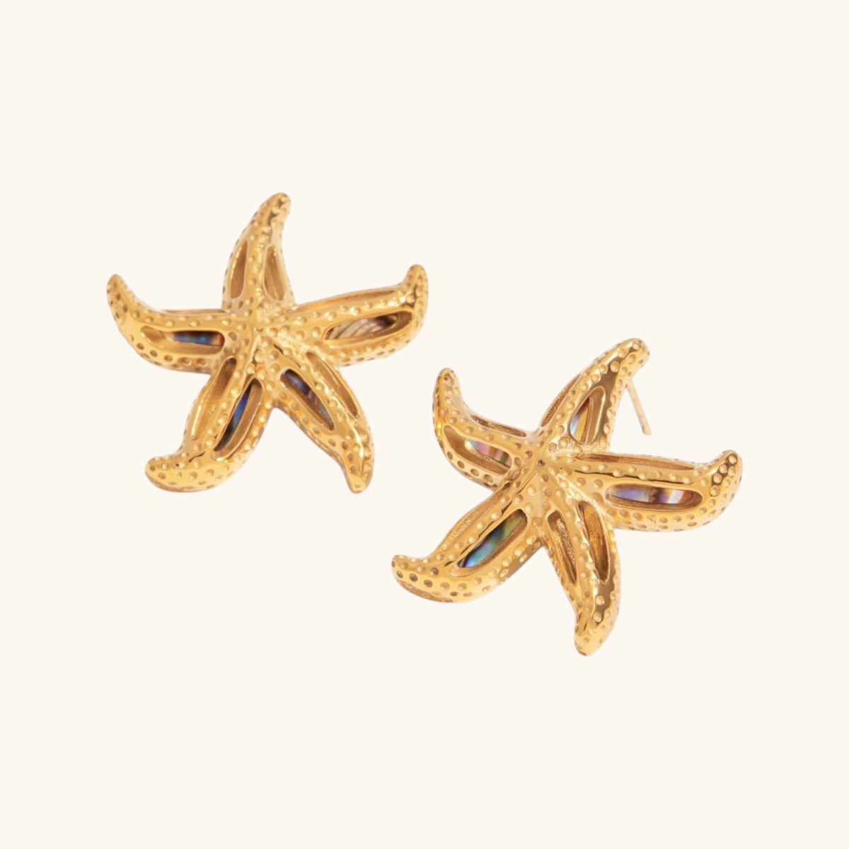 Close-up of scallop-shaped gold earrings with rainbow abalone shell detail