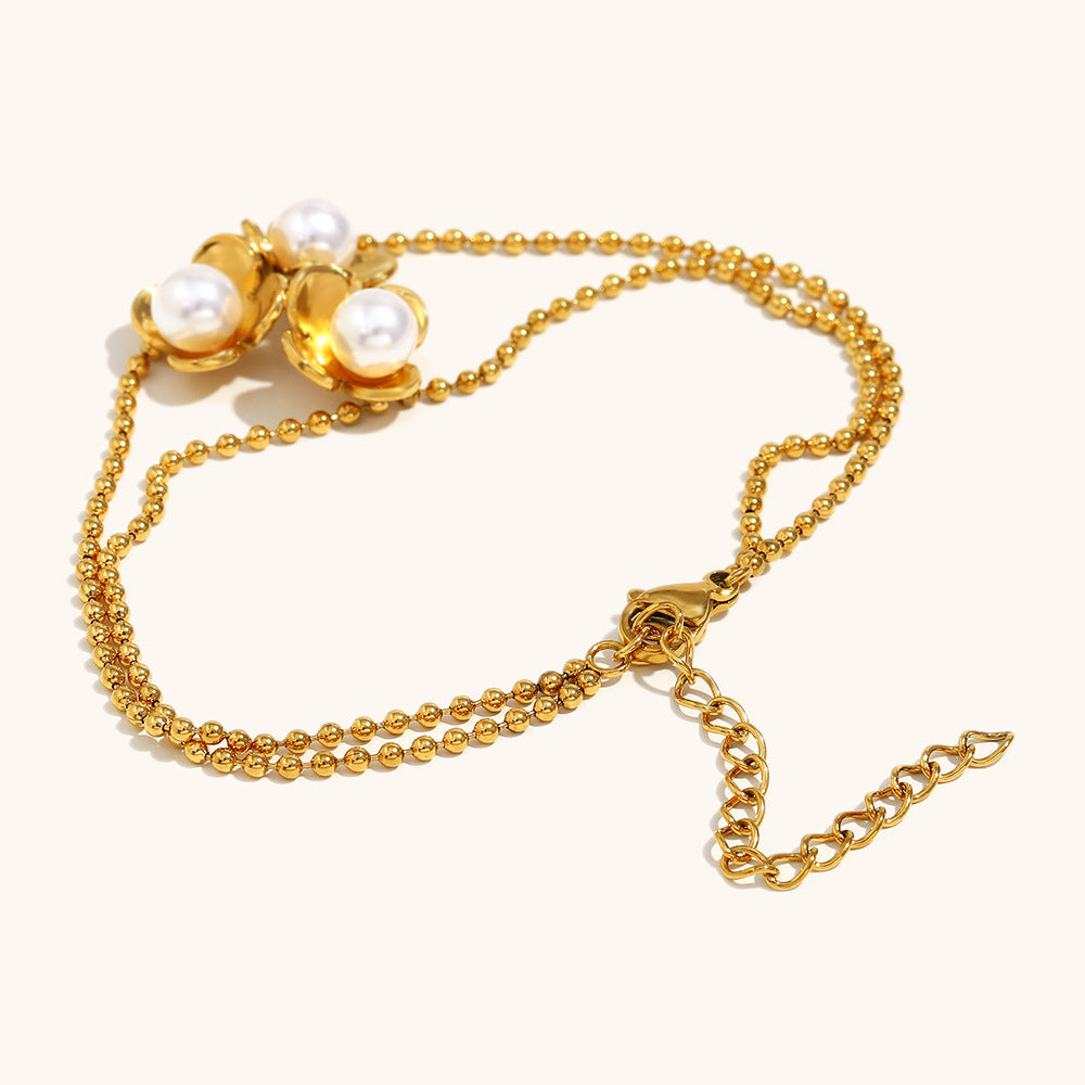Elegant adjustable bracelet with gold beads and blooming pearl flowers