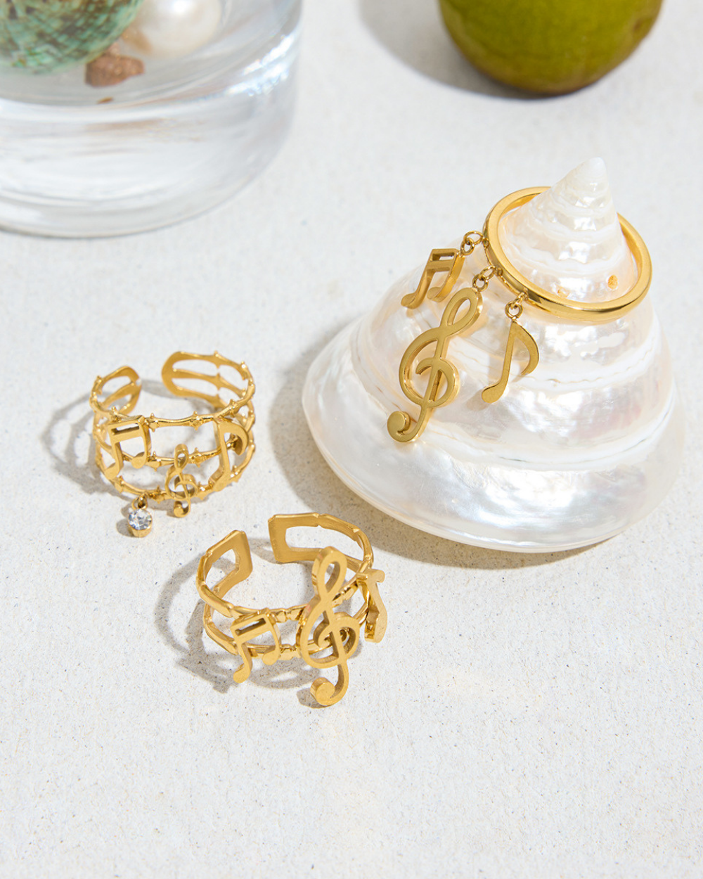 Gold rings with musical note designs on a white surface