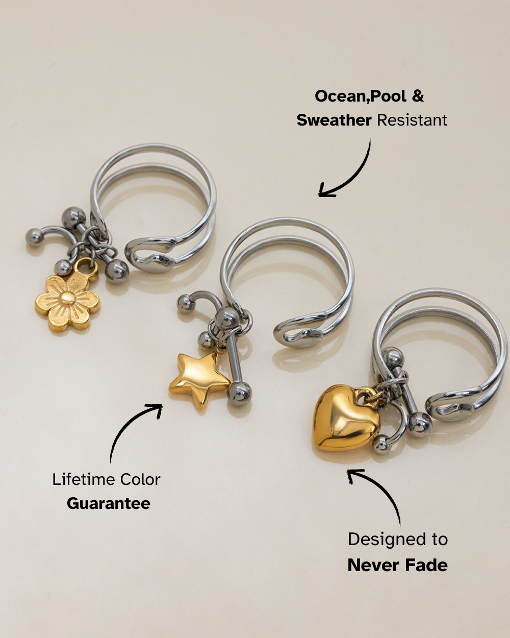 Three silver rings with gold charms on a light background