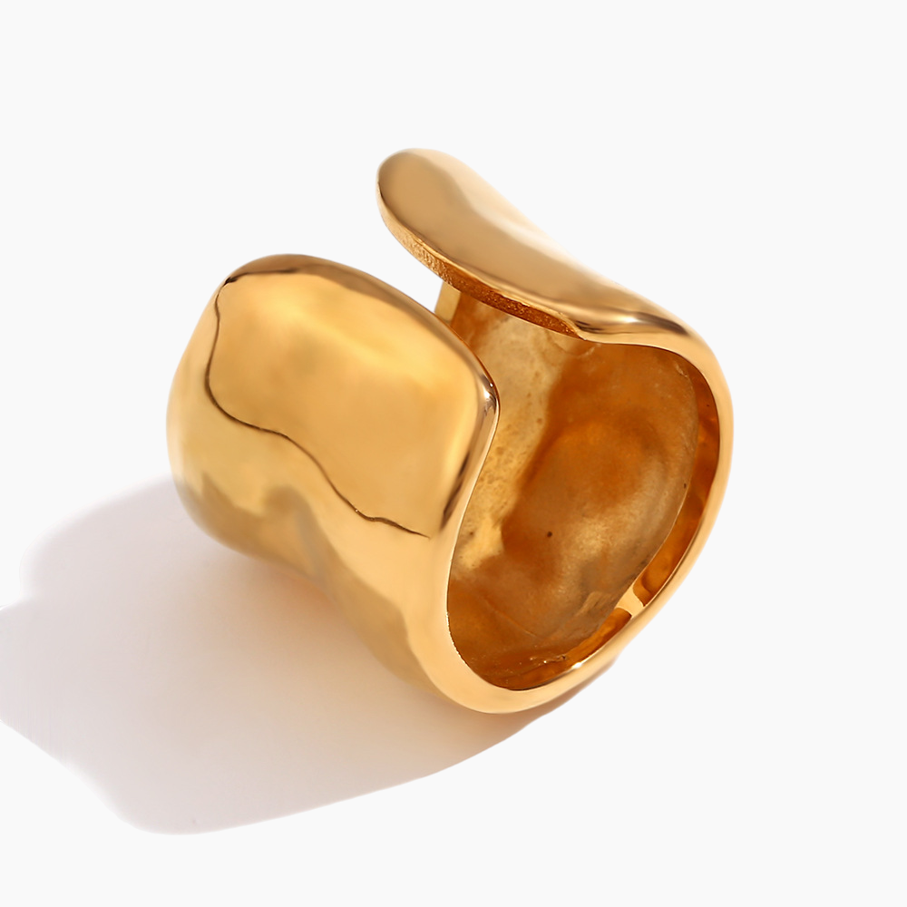 Gold ring with a wavy design on a white background