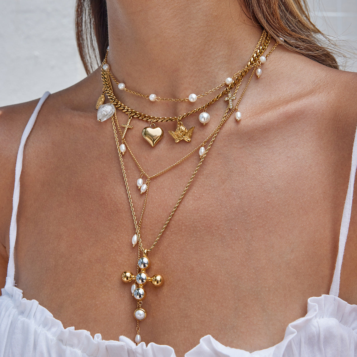 Model wearing charm bracelet and gold bangles under sunlight