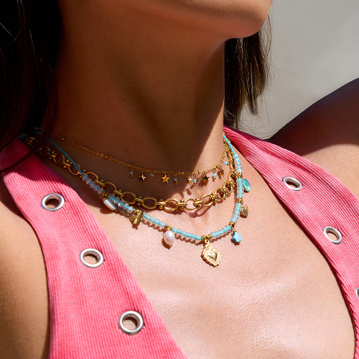 lifestyle image of model wearing summer charm necklace with layered gold chains