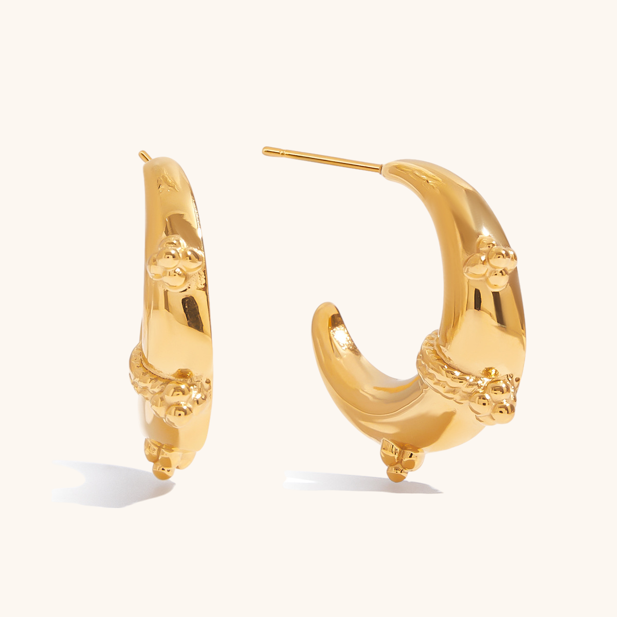 Side view of thick gold crescent earrings with vintage embellishments