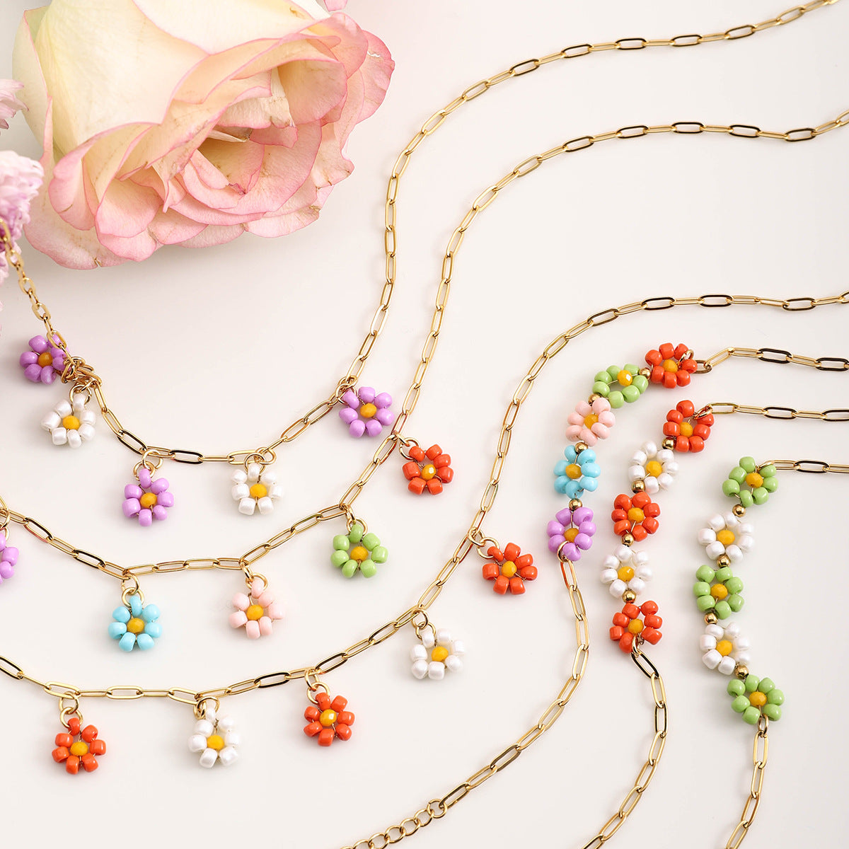 Variety of gold chain necklaces with colorful beaded flower pendants