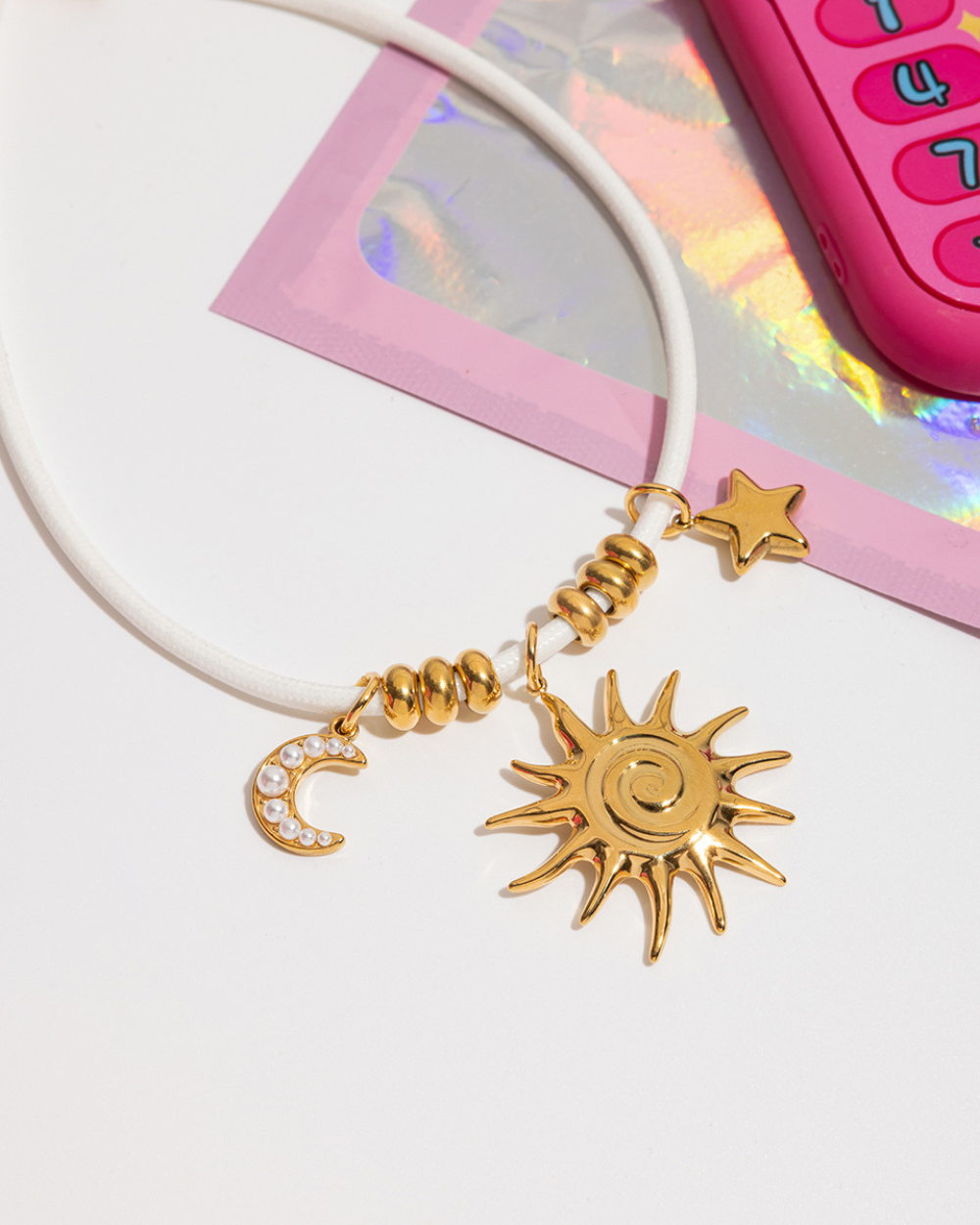 Bracelet with gold sun, moon, and star charms on a white background