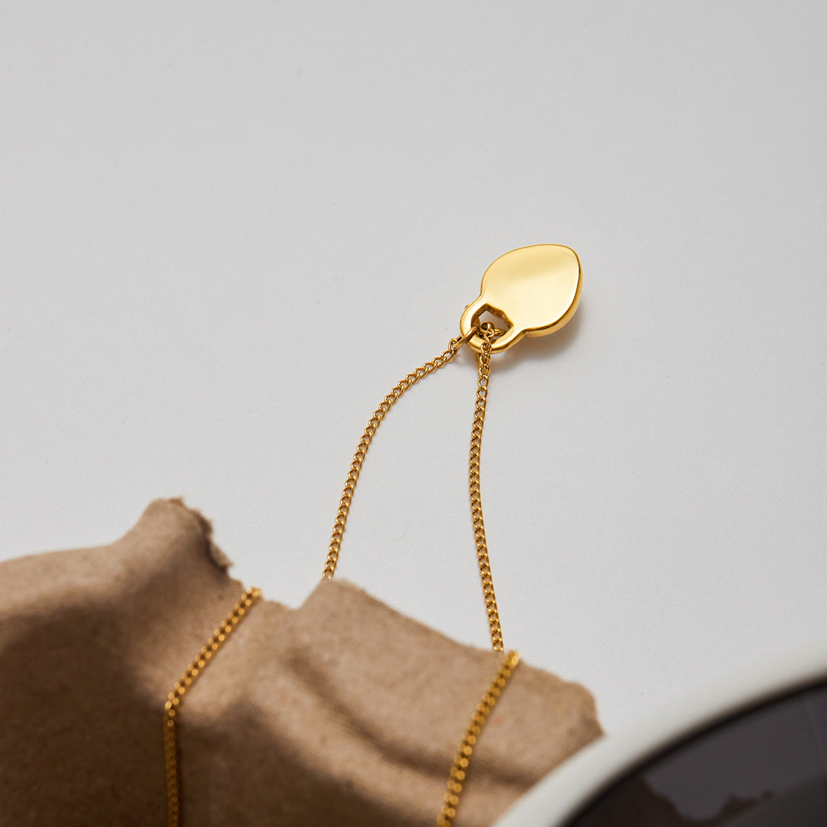 Close-up of the back side of a polished gold heart-shaped necklace pendant