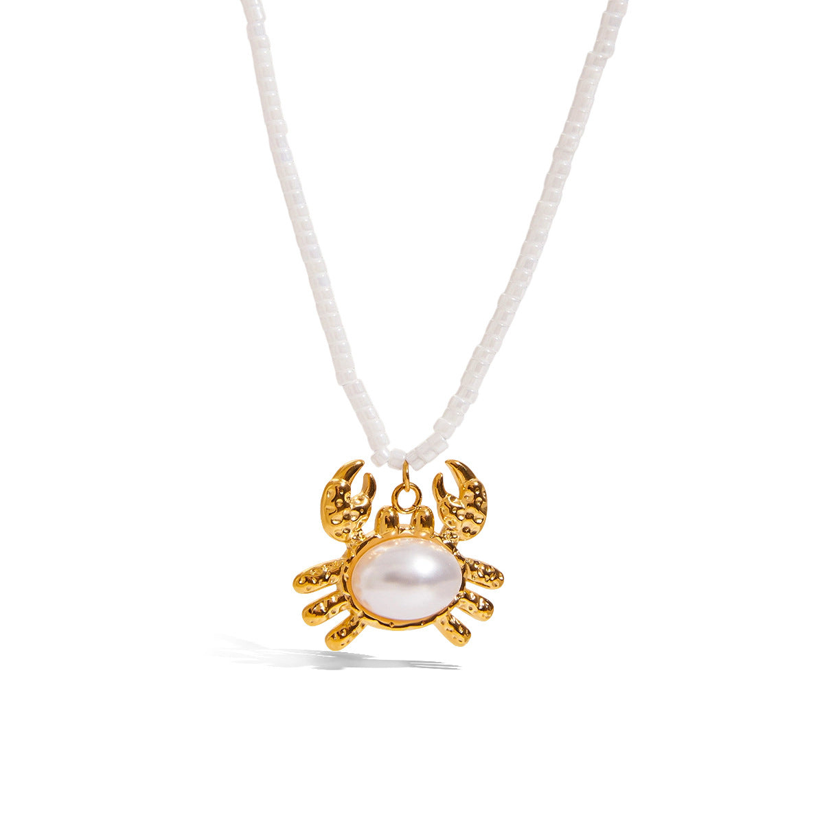 White beaded choker with gold crab pendant and pearl center