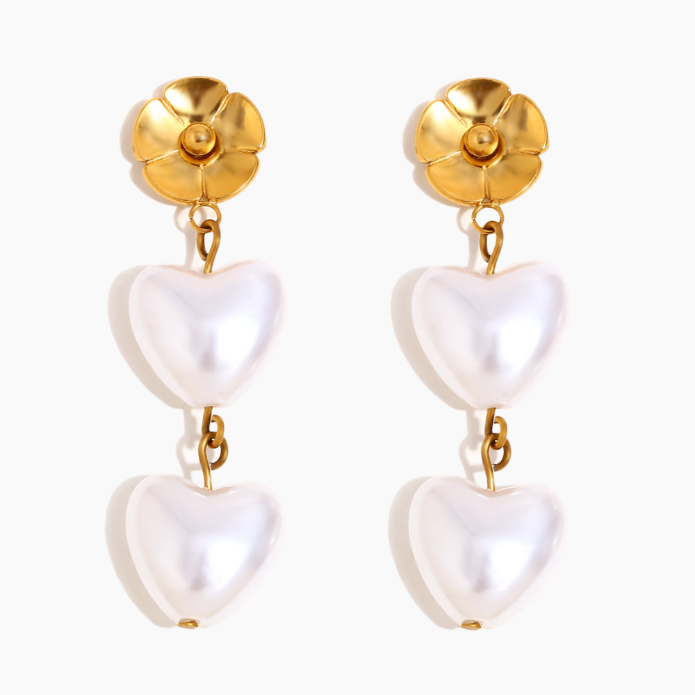 Pair of earrings with gold tops and white heart-shaped drops on a white background