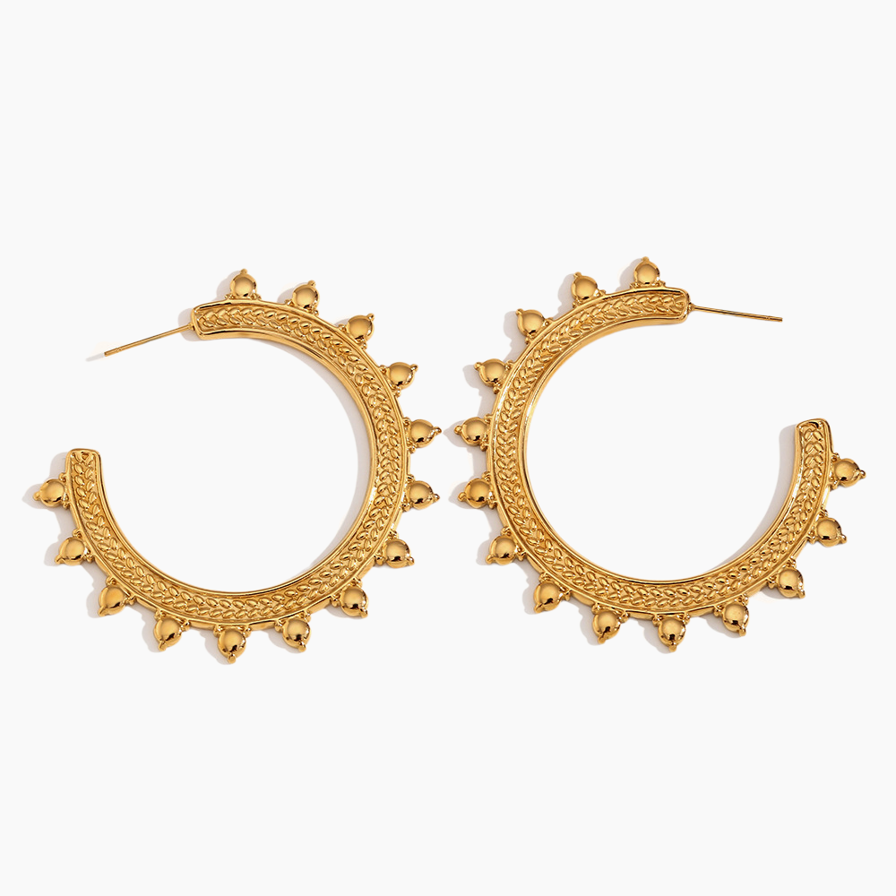 Gold hoop earrings with intricate designs on a white background