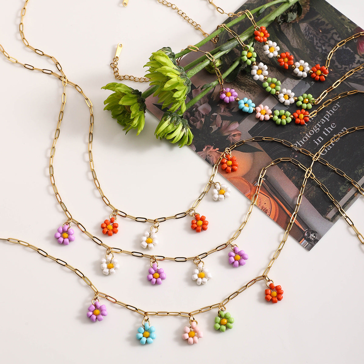 Colorful daisy chain necklaces displayed with flowers, perfect for summer gifts
