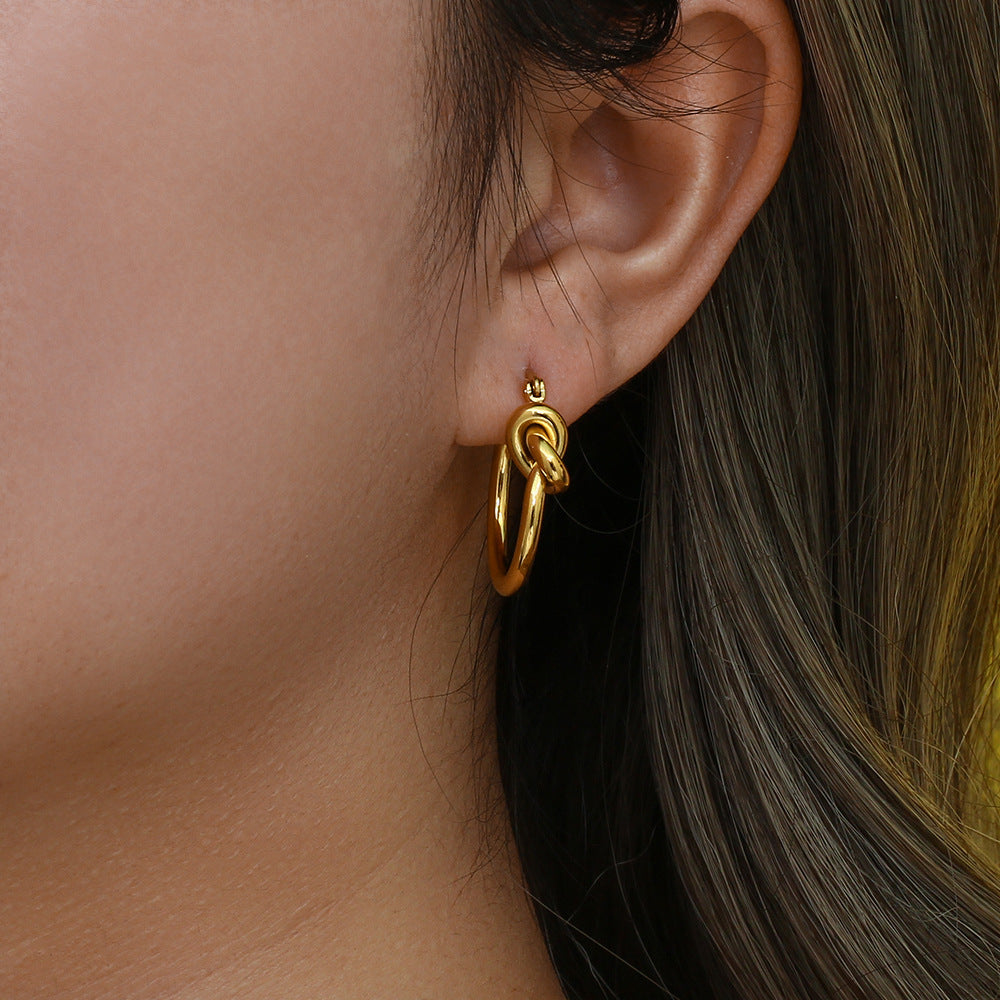 Model wearing knotted hoops styled with casual outfit and loose waves