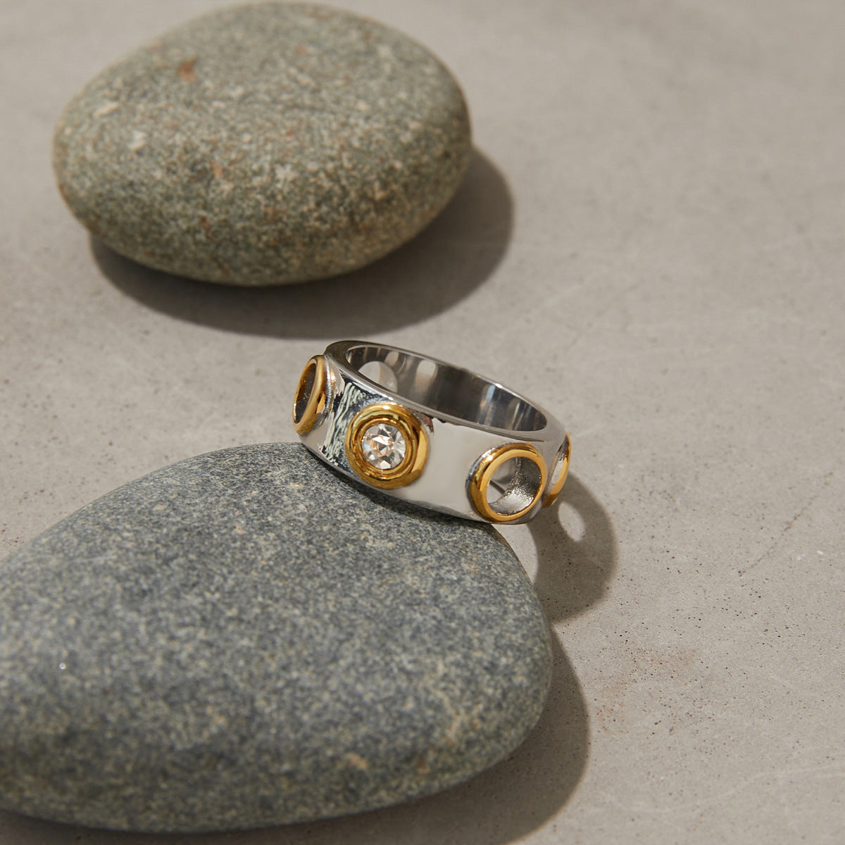 Model hand wearing bold dual-tone statement ring with open circles and cubic zirconia