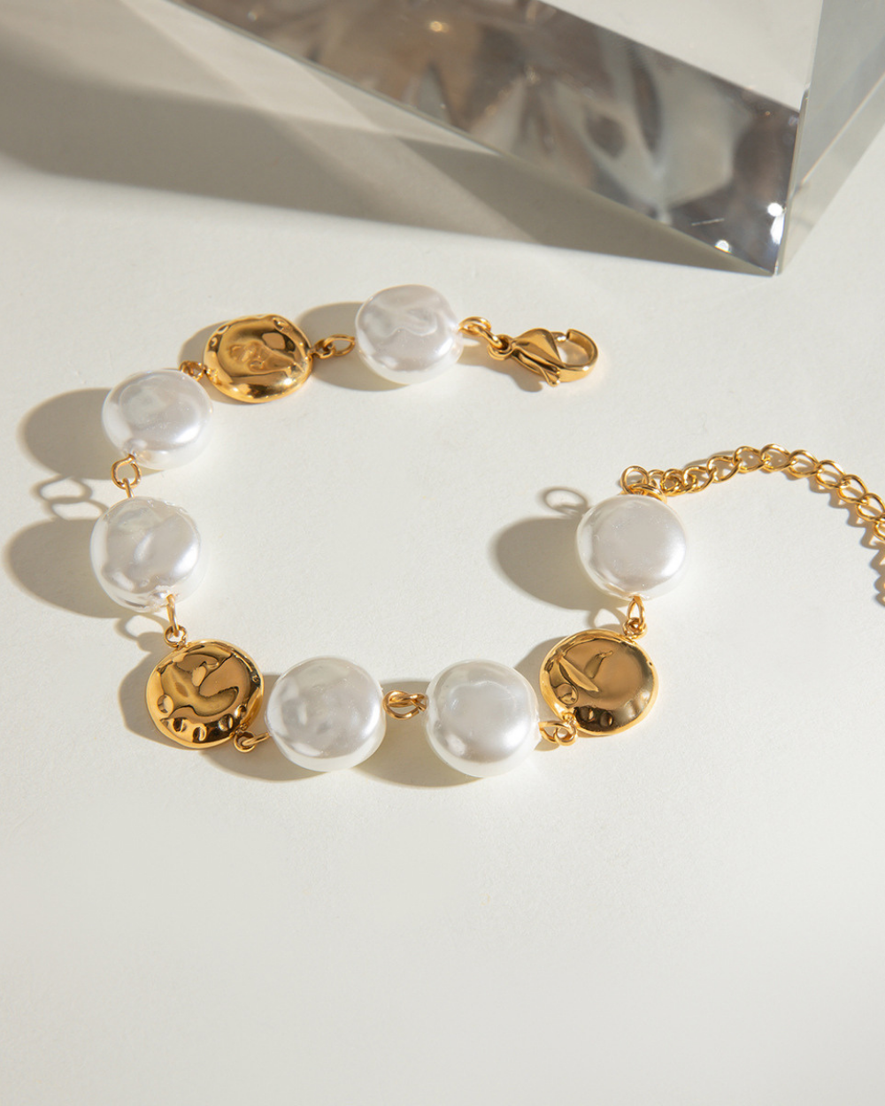Gold and white beaded bracelet on a light background