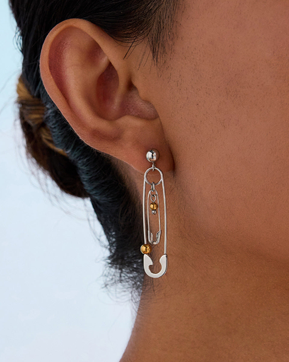 Long safety pin dangle earrings worn by model, edgy urban jewelry style