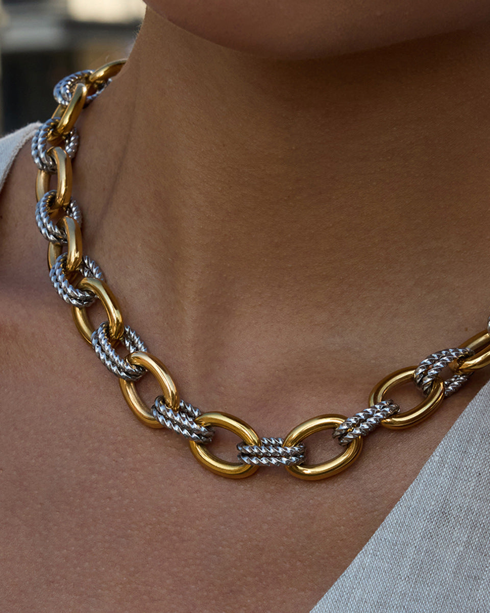Gold and silver chain necklace worn by a person