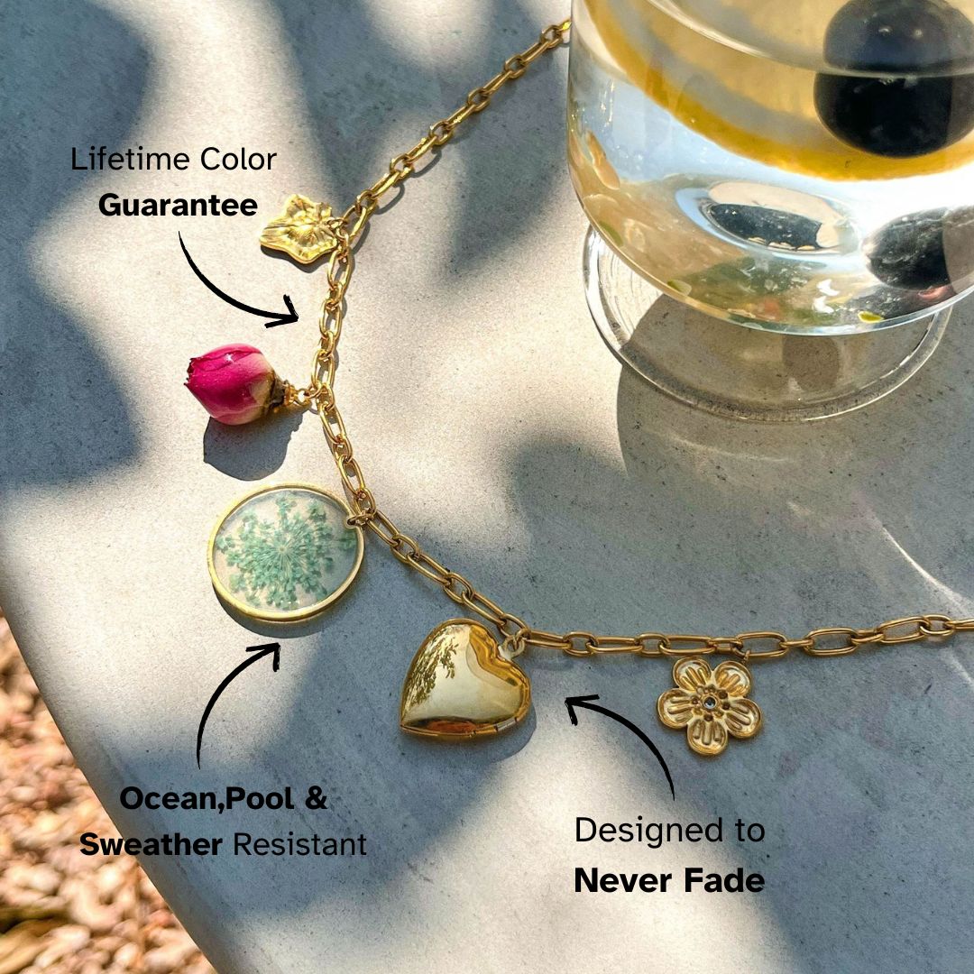 Flatlay of gold charm bracelet with rose, heart, and nature charms