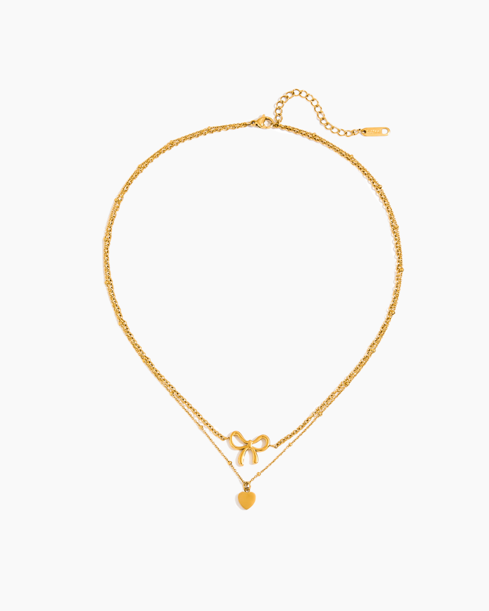 Gold necklace with bow and round pendant on a white background
