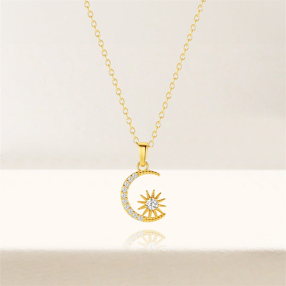Gold crescent and star pendant necklace displayed on minimal backdrop, dainty layering piece.