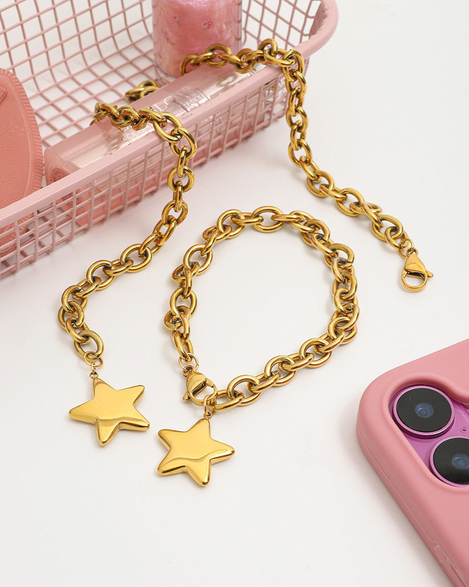 Gold chain with star pendants on a pink phone case and background
