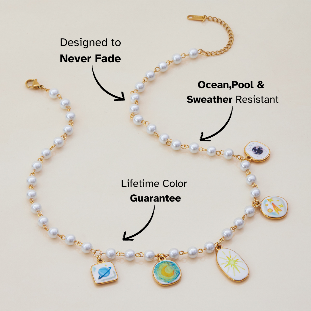 Close-up of pearl beaded necklace with planet, moon, and star charms in gold