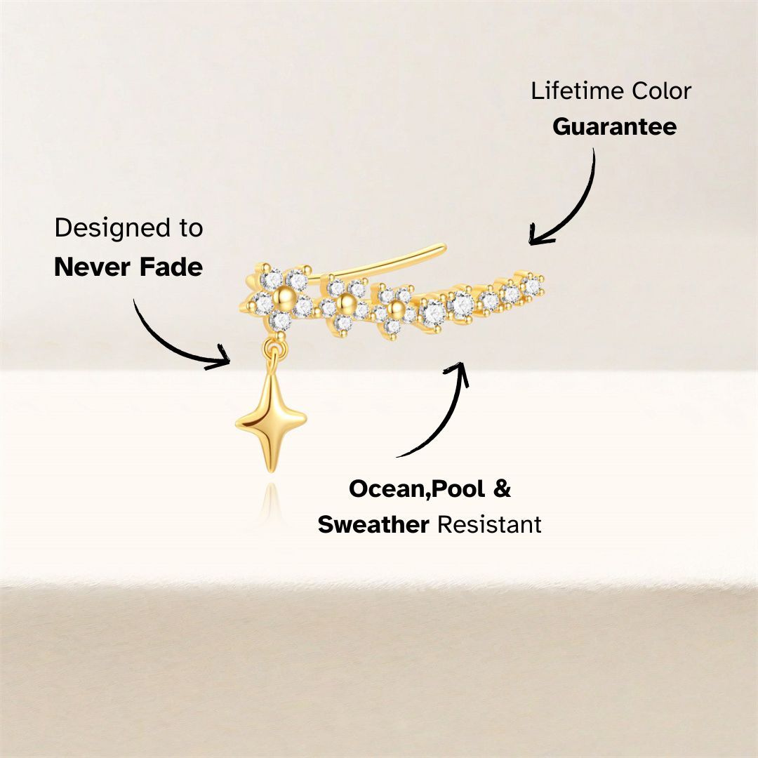 Single gold cuff earring with star charm and zircon crystals, product close-up