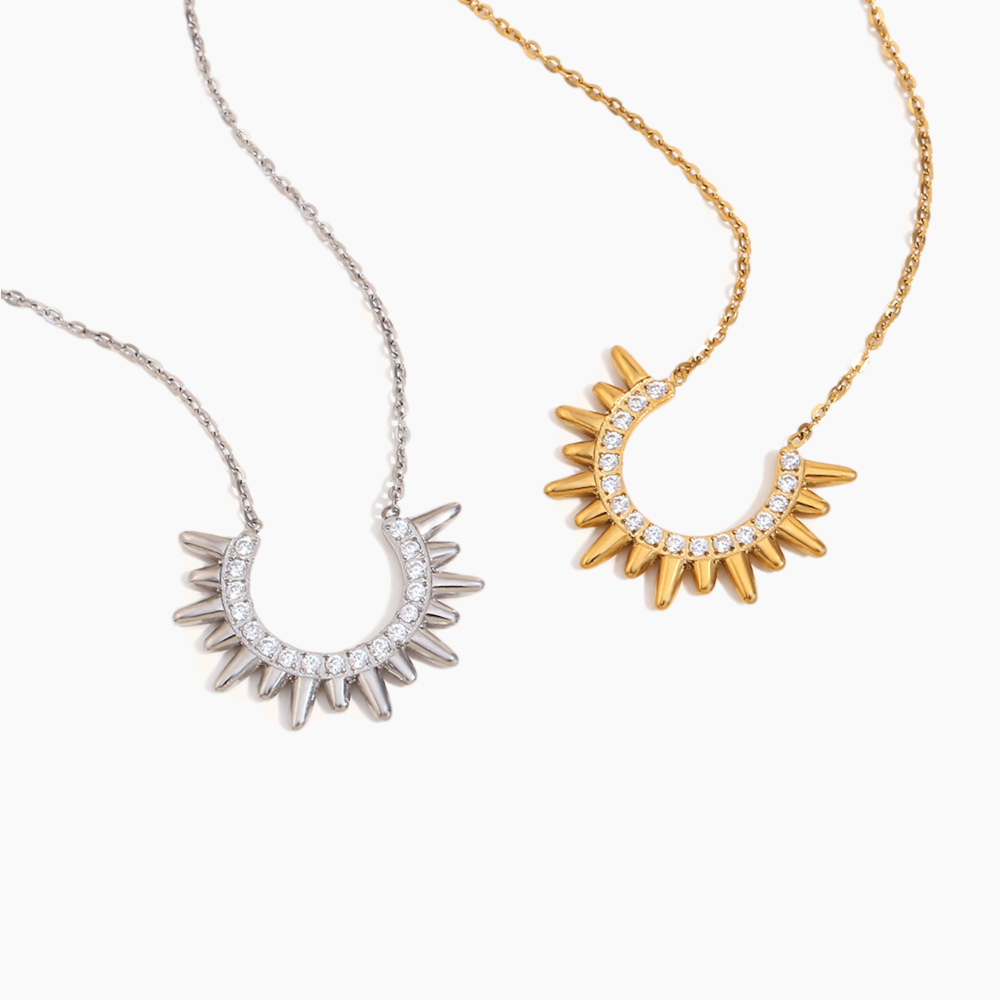 Two sun-shaped necklaces, one gold and one silver, on a white background.