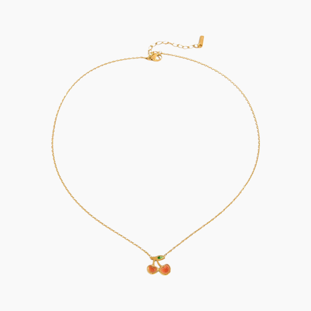 Gold necklace with cherry pendant on a white background