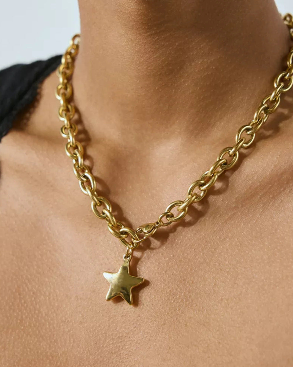 Model wearing chic gold star necklace with black lace top, elegant and stylish look.