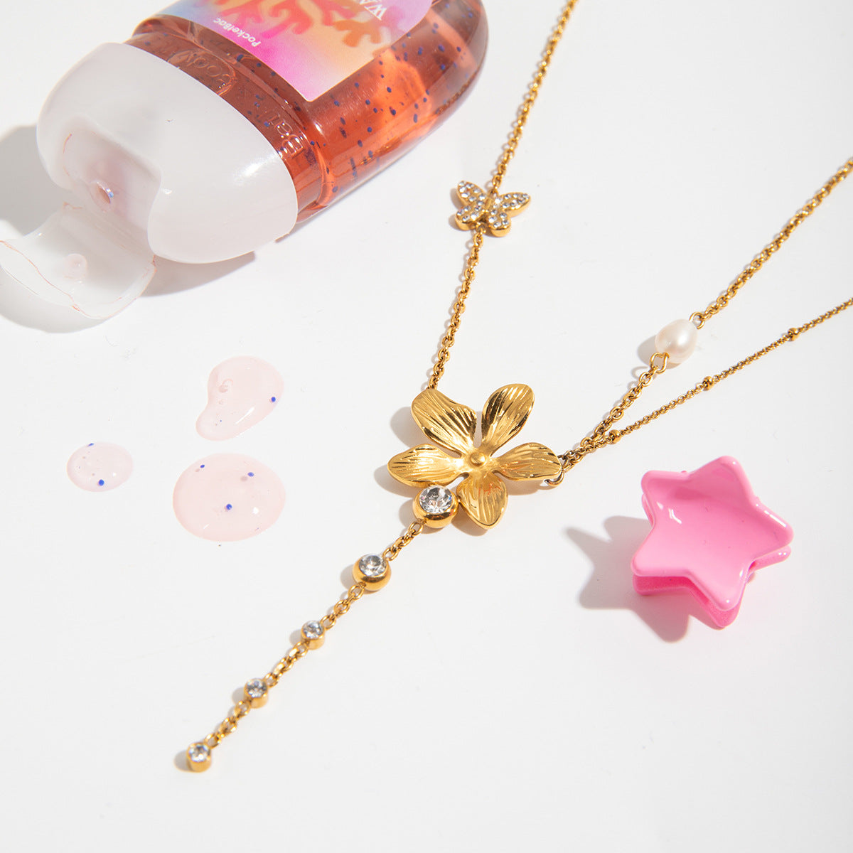 Gold necklace with a flower pendant on a white background