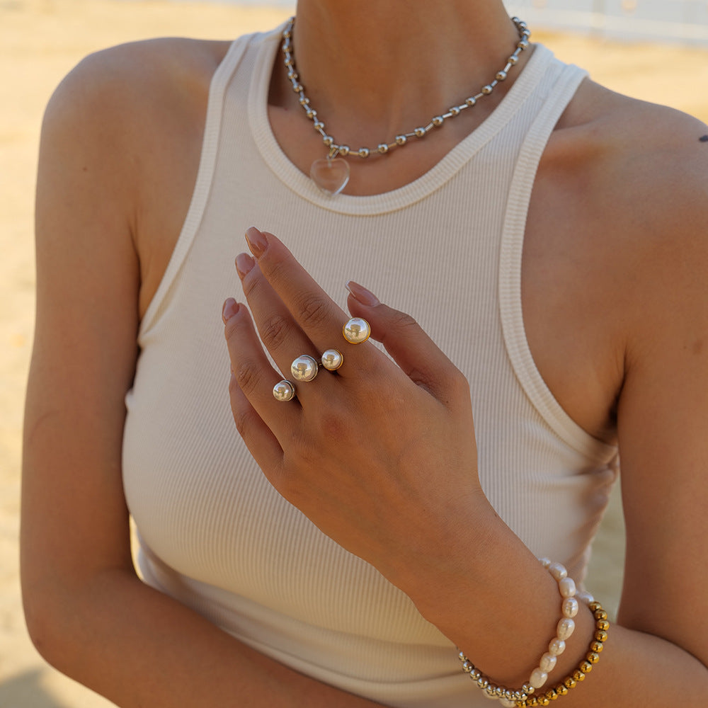 Stacked pearl rings on fingers styled with white summer outfit