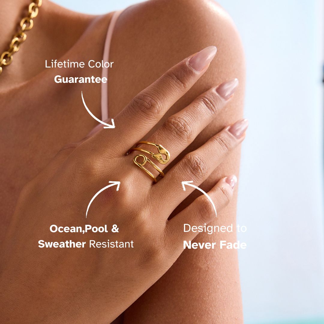 Model wearing gold safety pin ring and gold star necklace on shoulder close-up