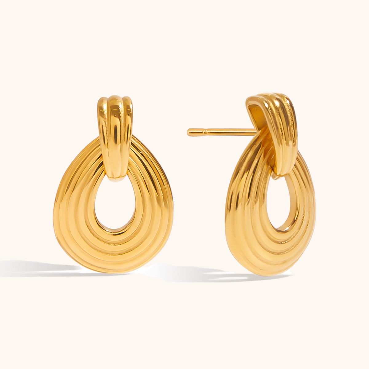Side view of thick gold teardrop stud earrings with polished finish