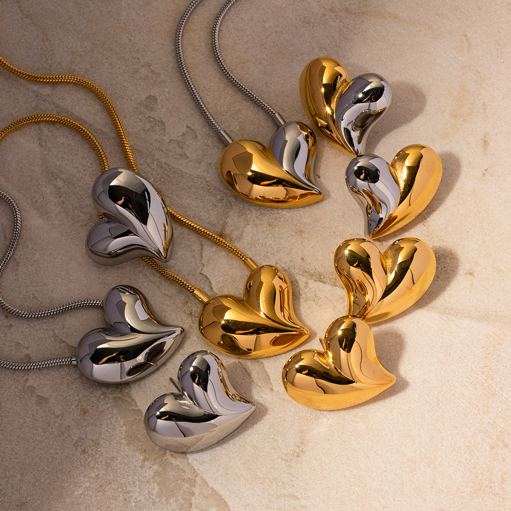 Display of multiple chunky heart earrings and necklaces, elegant mix of metals
