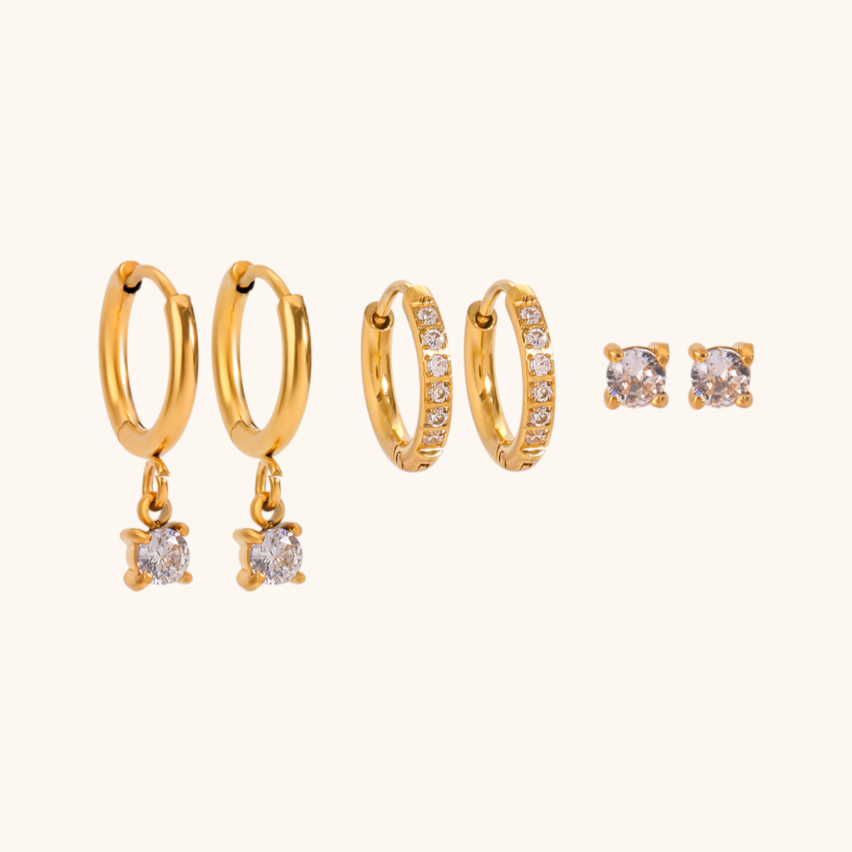 Shiny gold hoops inlaid with tiny clear crystals, laid on bright neutral backdrop.
