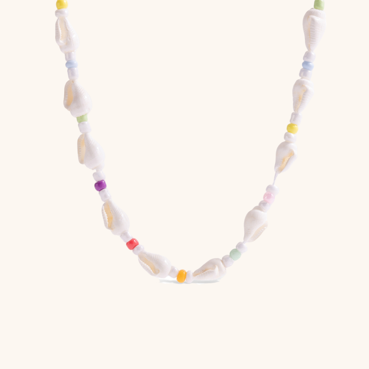 Close-up of the Coastal Candy necklace with colorful seed beads and natural shell details on a neutral background.