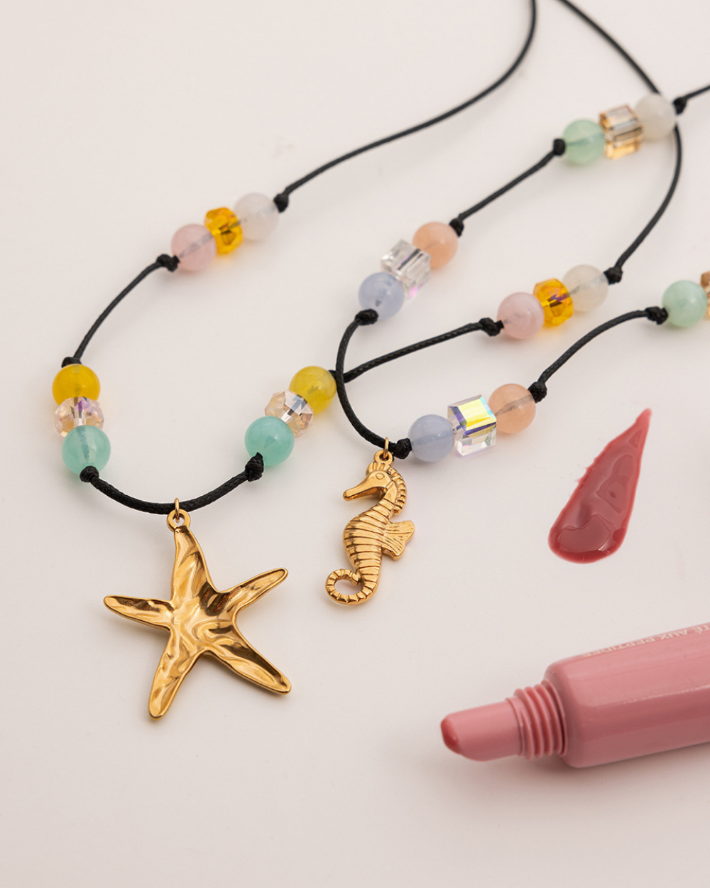 Necklaces with starfish and seahorse pendants on a white background