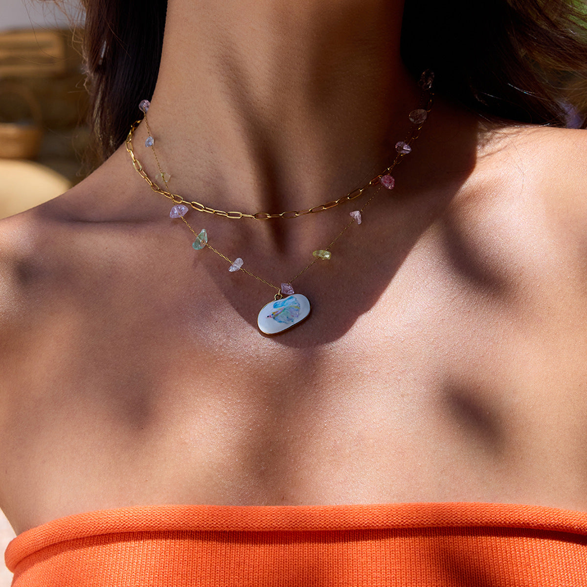 Pastel gemstone necklace with colorful fish pendant on model’s neck under sunlight