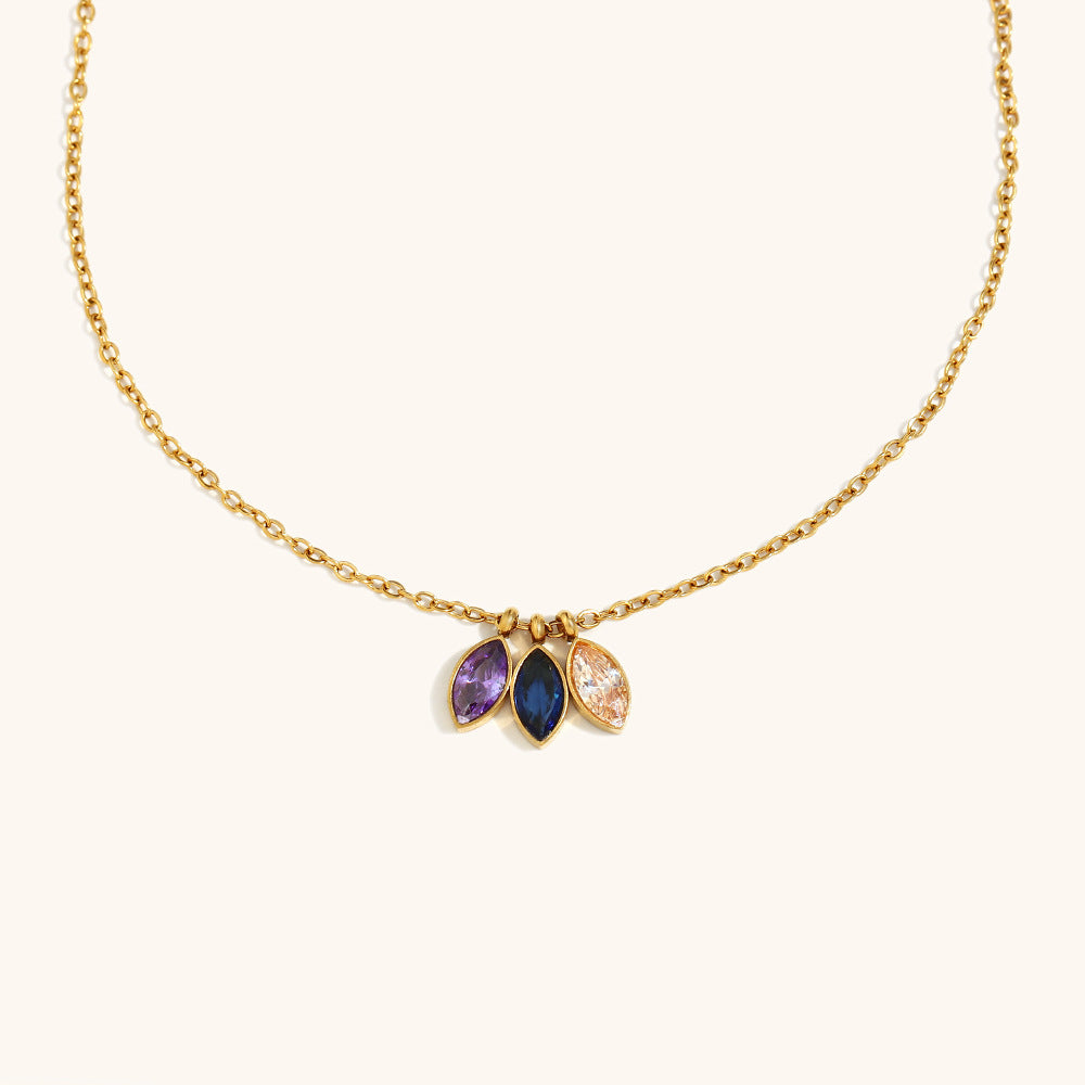 Close-up of gold necklace with purple, blue, and champagne teardrop gemstones