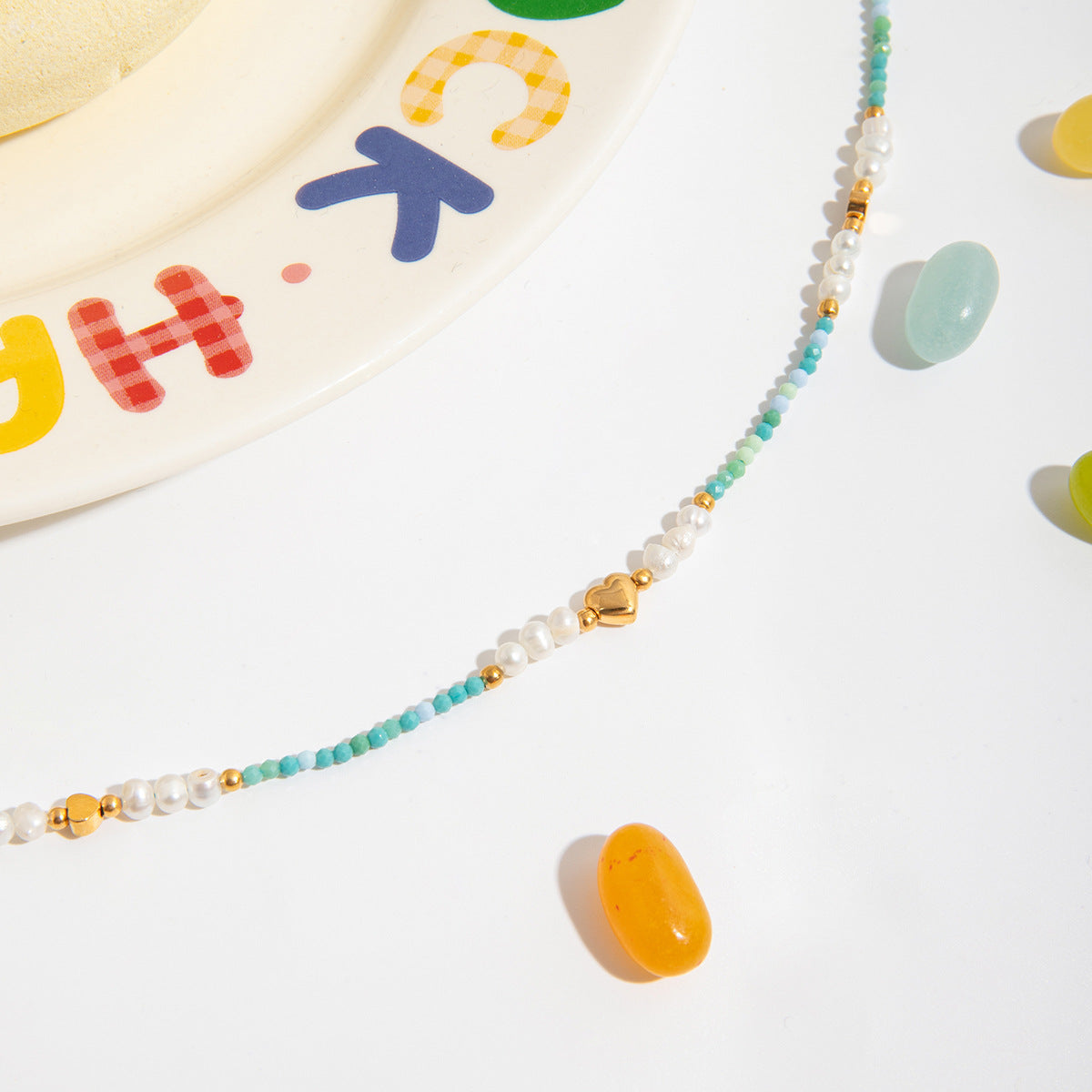 colorful flatlay with candy and handcrafted bead necklace