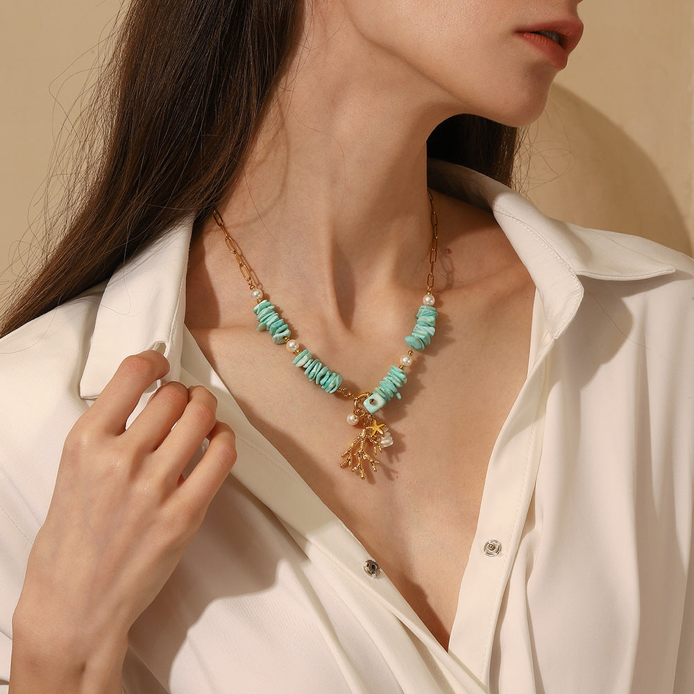 Model wearing a turquoise stone and gold charm necklace for summer outfits