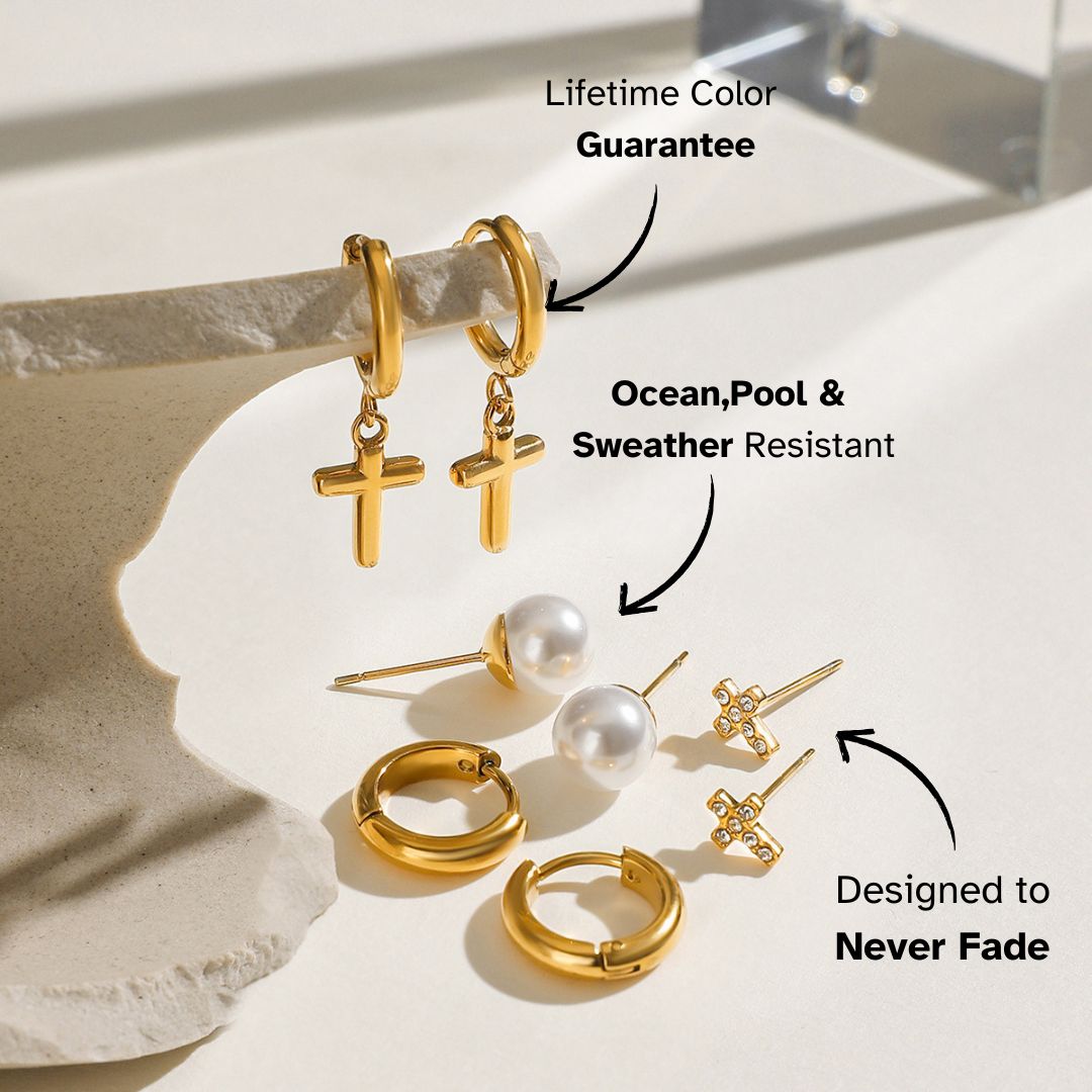 Gold cross hoop earrings paired with pearl studs in a light-filled setting